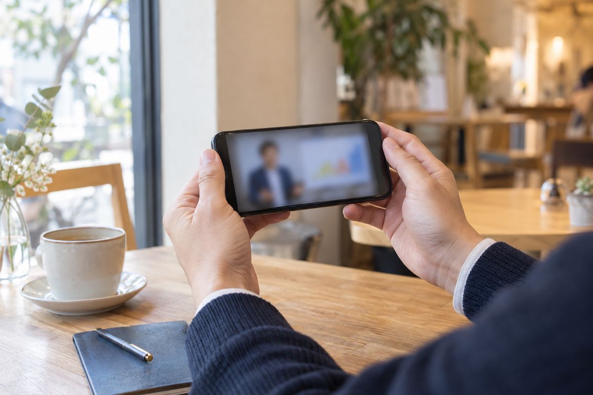 カフェでスマートフォンの動画講座を見る手元